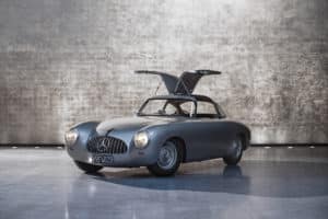 Mercedes-Benz 300 SL Rennsportwagen (W 194) von 1952 von Mercedes-Benz Classic. Exterieurfoto von links vorn mit geöffneten Flügeltüren.